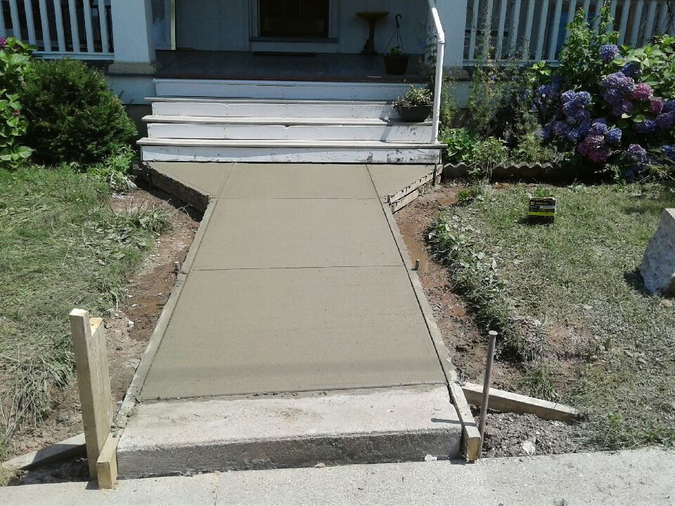 Concrete front walk leading to white porch steps
