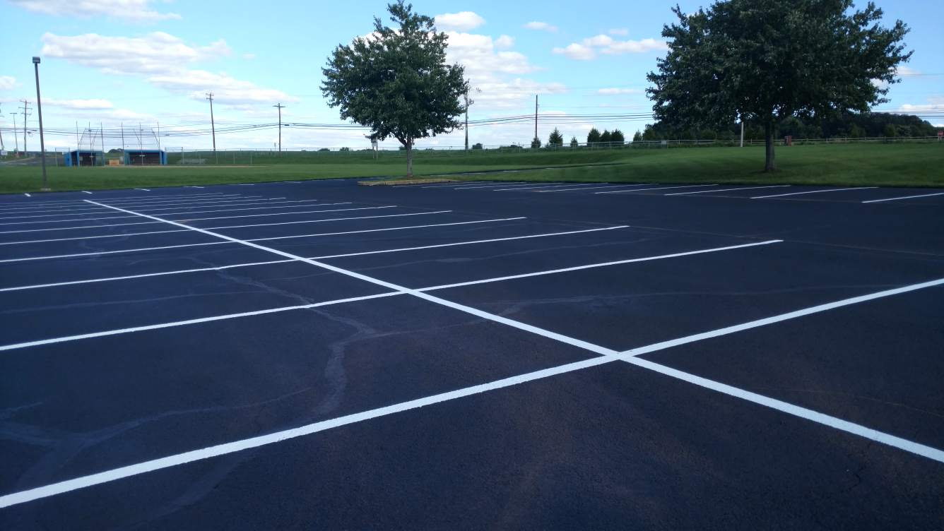 White parking-space markings across a dark asphalt lot